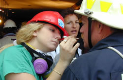 Emergency worker helps N.Y.C. firefighter during a break from his recovery work at the World Trade Center disaster site. FEMA news photo by Michael Rieger.