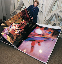 UW Libraries Director Betsy Wilson has her hands full turning a page of the world's largest book. One of the copies is now housed at Suzzallo Library. Photo by Kathy Sauber.