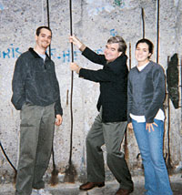 Mark Emmert, center, tries to pull down a support rod in the Berlin Wall as his children, Steve and Jennifer, pose for the camera. Emmert received two Fulbright fellowships to the former East Germany in 1991 and 1994. Photo courtesy Mark Emmert.