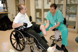 UW surgeon Douglas Smith ecamines the leg of Oregon National Guardsman Matthew Braddock, who is from Vancouver, Wash. Smith performed the amputation at Brooke Army Medical Center in San Antonio in February. Photo by Susan Gregg-Hanson.