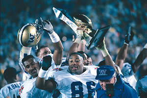 Don James dodges a photographer's camera as players celebrate their 1992 Rose Bowl victory over Michigan. Photo by Irene Fertik.