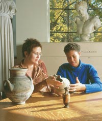 Classics Professor Sarah Culpepper Stroup (left) and Allyssa Lamb discuss archaeological artifacts similar to those found at a dig at Tel Dor, Israel. Stroup asked Lamb to join her and other students excavating the Bronze Age ruins. Photo by Kathy Sauber.