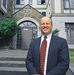 Douglas A. Luetjen, '80, stands in front of the Sigma Chi chapter house just north of the UW campus. Photo by Kathy Sauber.