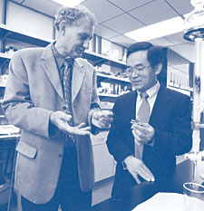 Chemistry Professor Larry Dalton (left) shares his photonics expertise with Business Professor Michael Song, who heads the UW's Center for Technology Entrepreneurship. Photo by Dan Lamont.