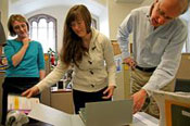 Heidi Nance, left, Kayla Johnson and Thomas Deardorff with a 100-year-old book from ILL