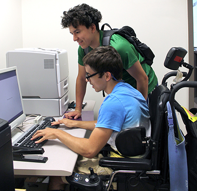 Two students use assistive technology.