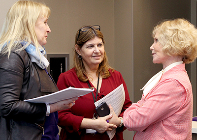 Sheryl Burgstahler talks to two participants.