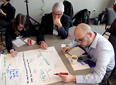 Participants write their input to a statement on a large post-it note.