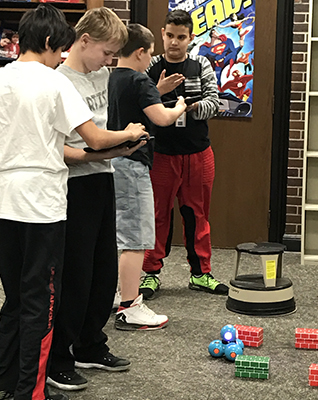 Deaf Kids Code participants test their code as they make a robotic car navigate an obstacle course.