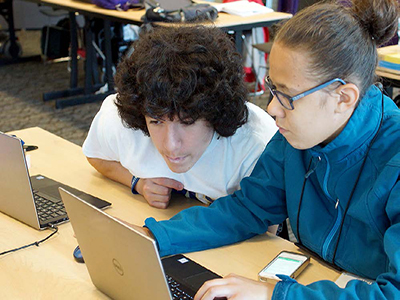 Two students use a computer.