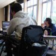 Student in a wheelchair uses a laptop during class.