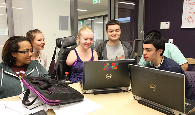 A diverse group of students working on a computer project