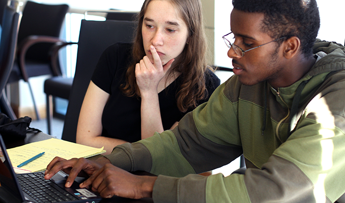 Two students collaborate on a computing project