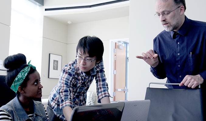 A computing student, an instructor, and a sign language interpreter work together