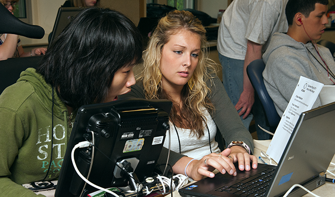 Two students use assistive technology to work on a computing project