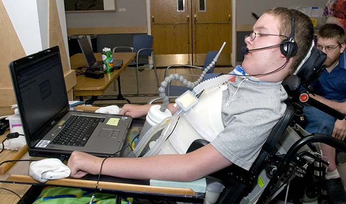 A student with a mobility impairment works on a computing project