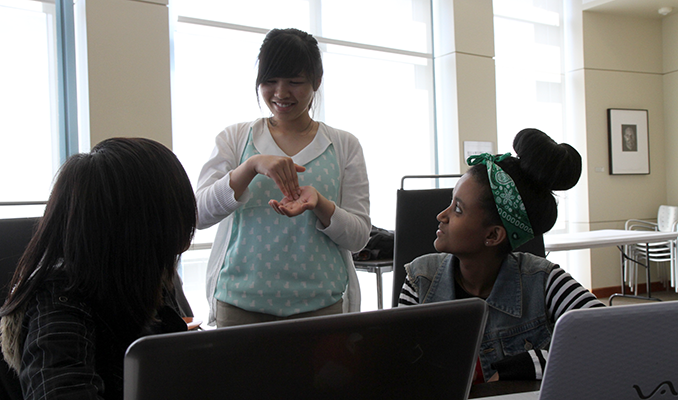 A computing student uses sign language to collaborate with others