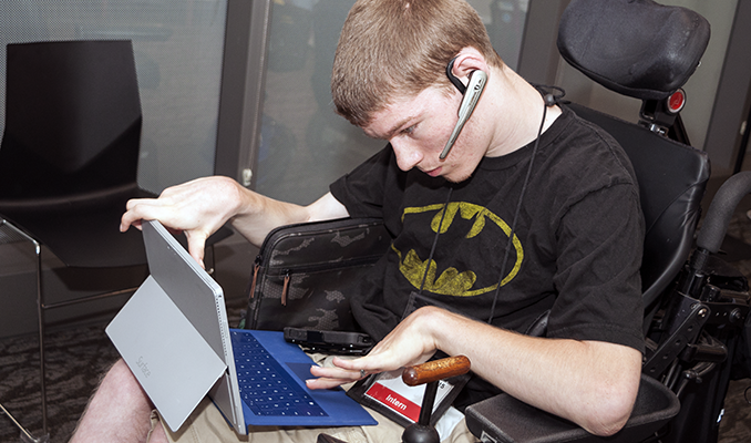 A student uses a headset, tablet, and keyboard to work on a project