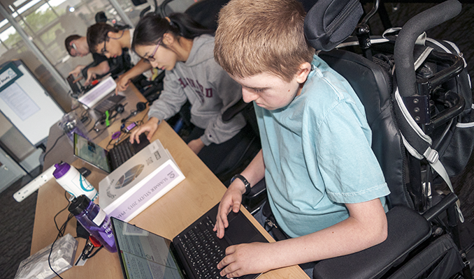 A group of students with diverse abilities work in a computer lab