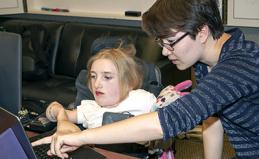 An instructor shows a student how to use a tool on the computer.