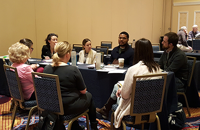 Participants sit around a table and talk.