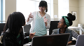 Three deaf students of color work on a computing project together. Three deaf students of color work on a computing project together.