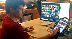 A student uses his Augmentative and Alternative Communication device to access a Zoom class.