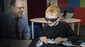 An instructor and a blind student with some technology.