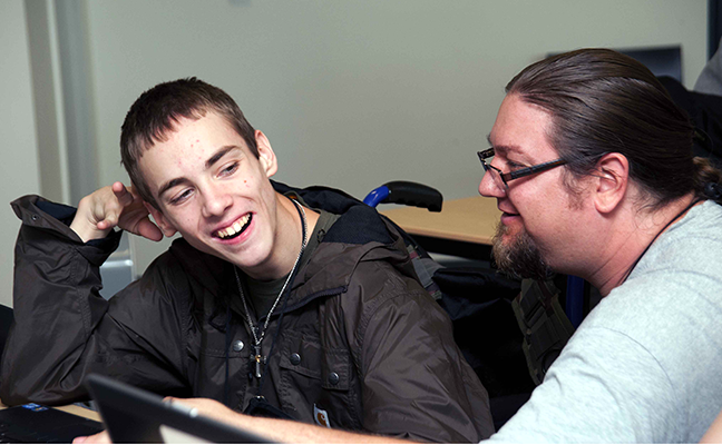 An educator assists a computing student An educator assists a computing student
