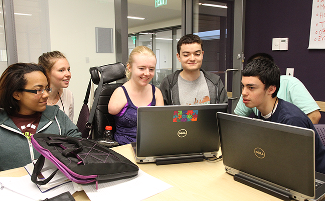 A diverse group of students working on a computer project