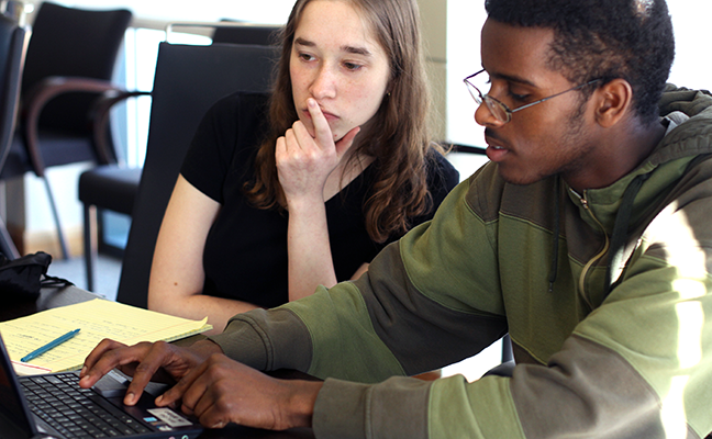 Two students collaborate on a computing project