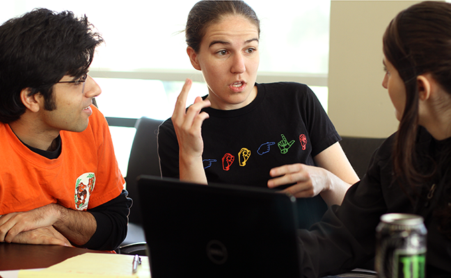 A TA interprets between a deaf computing student and a hearing TA.