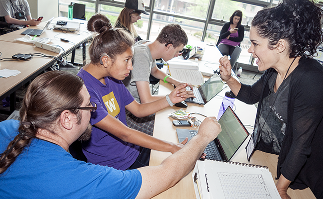A computing student works with a sign language interpreter and a computing educator
