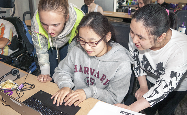 Three students work on a computing project together Three students work on a computing project together