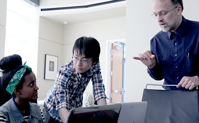 A computing student, an instructor, and a sign language interpreter work together