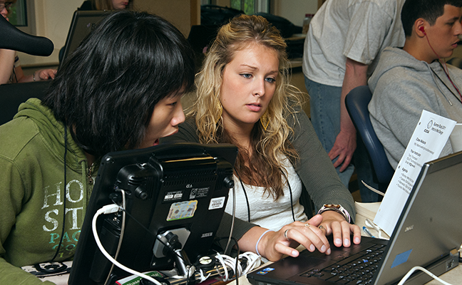 Two students use assistive technology to work on a computing project Two students use assistive technology to work on a computing project