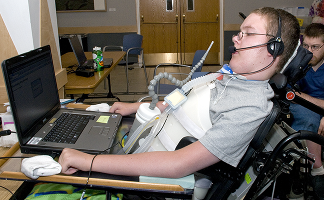 A student with a mobility impairment works on a computing project A student with a mobility impairment works on a computing project