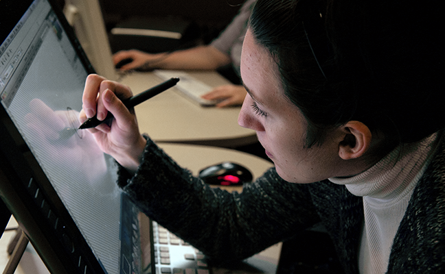 A student uses a stylus to work on a computing project