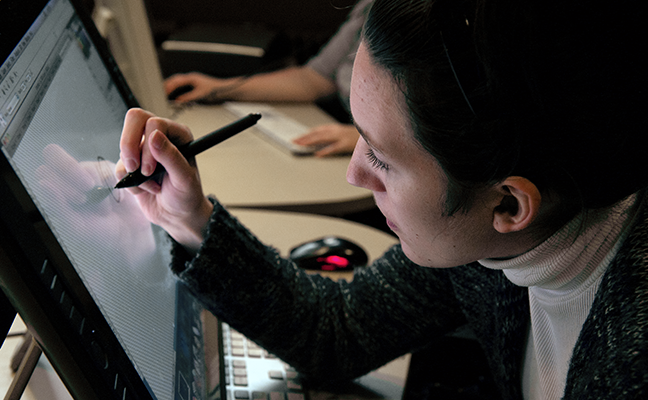 A student uses a stylus to work on a computing project A student uses a stylus to work on a computing project