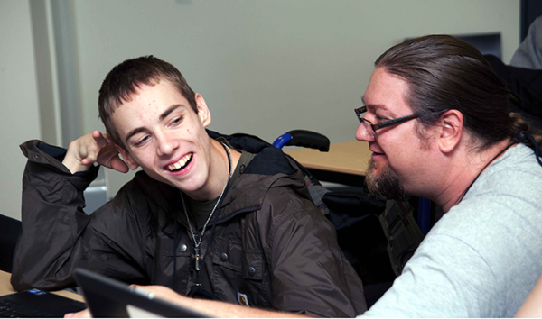 An educator assists a computing student
