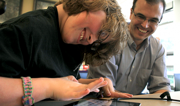 An instructor works with a student using a tablet