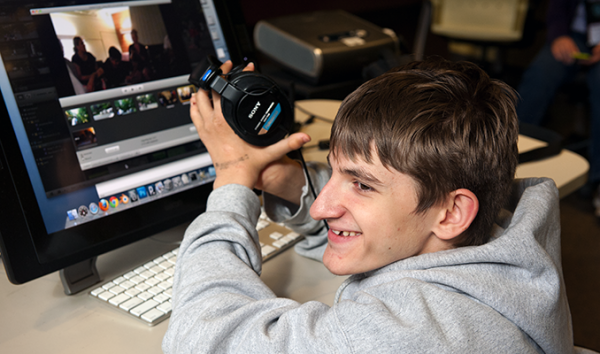 A student uses headphones to work on a computing project A student uses headphones to work on a computing project