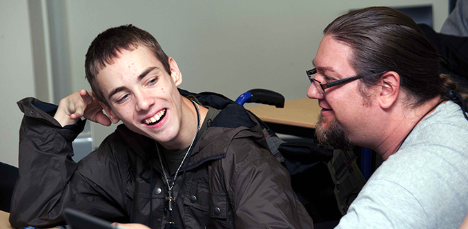 An educator assists a computing student