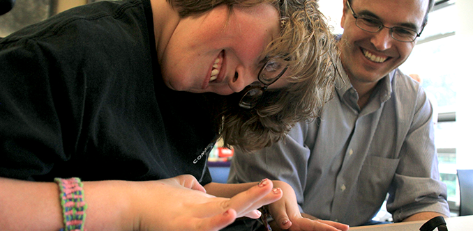 An instructor works with a student using a tablet