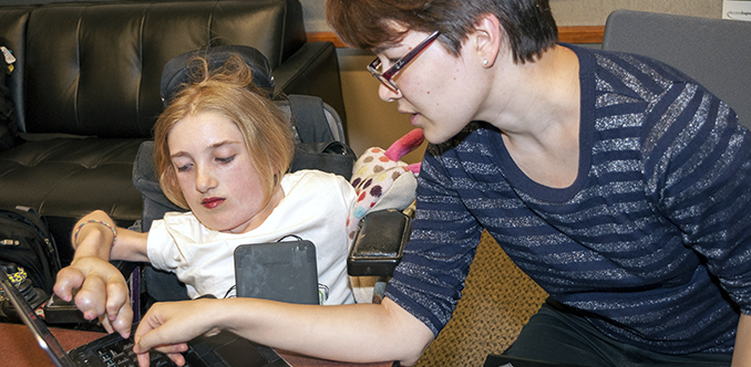 An instructor works with a student on a computing project