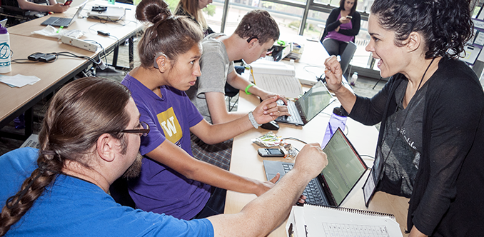 A computing student works with a sign language interpreter and a computing educator