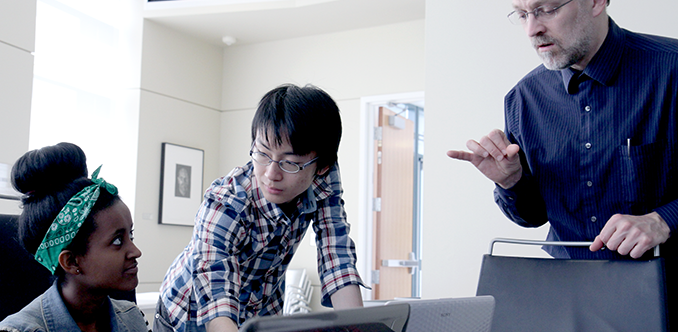 A computing student, an instructor, and a sign language interpreter work together