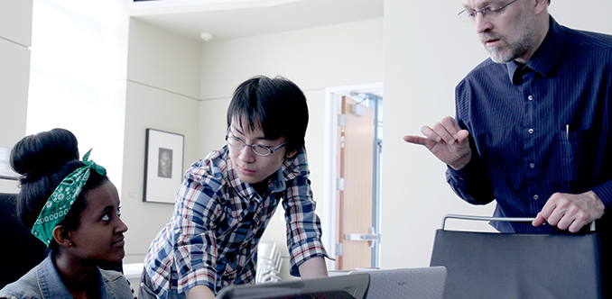 A computing student, an instructor, and a sign language interpreter work together A computing student, an instructor, and a sign language interpreter work together