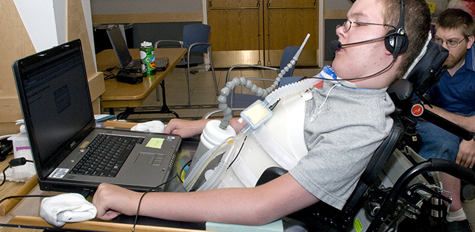 A student with a mobility impairment works on a computing project