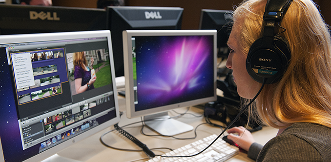 A student using headphones works on video editing on her computer A student using headphones works on video editing on her computer